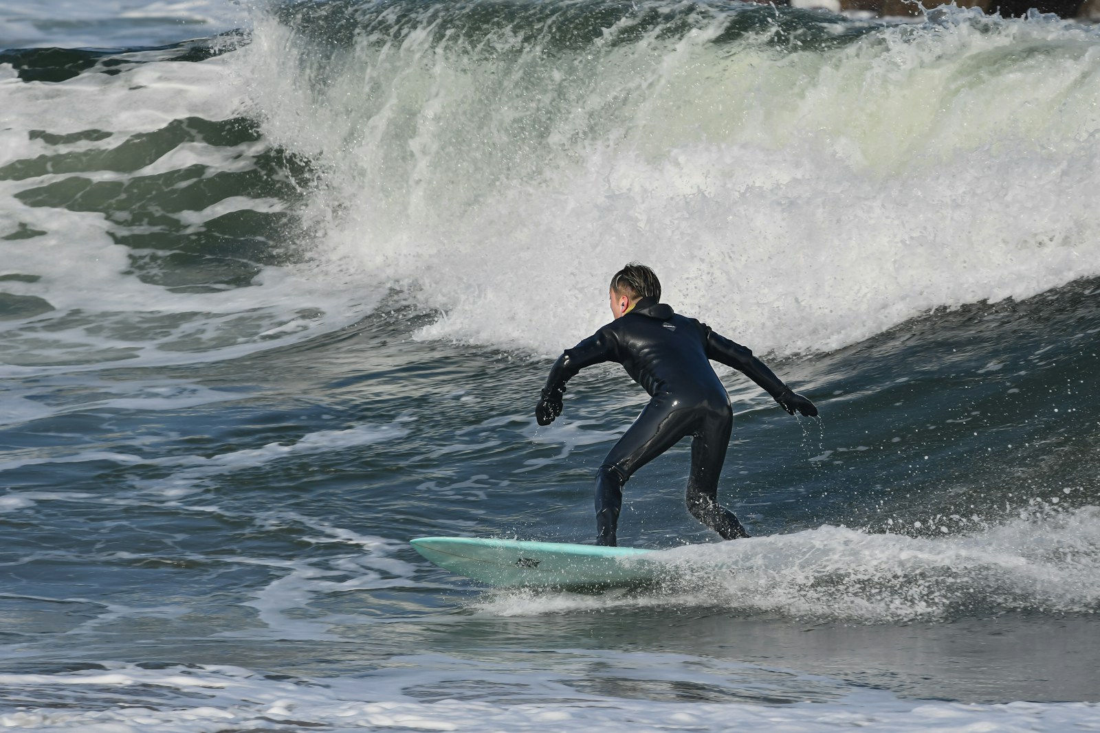 A man riding a wave on top of a surfboard